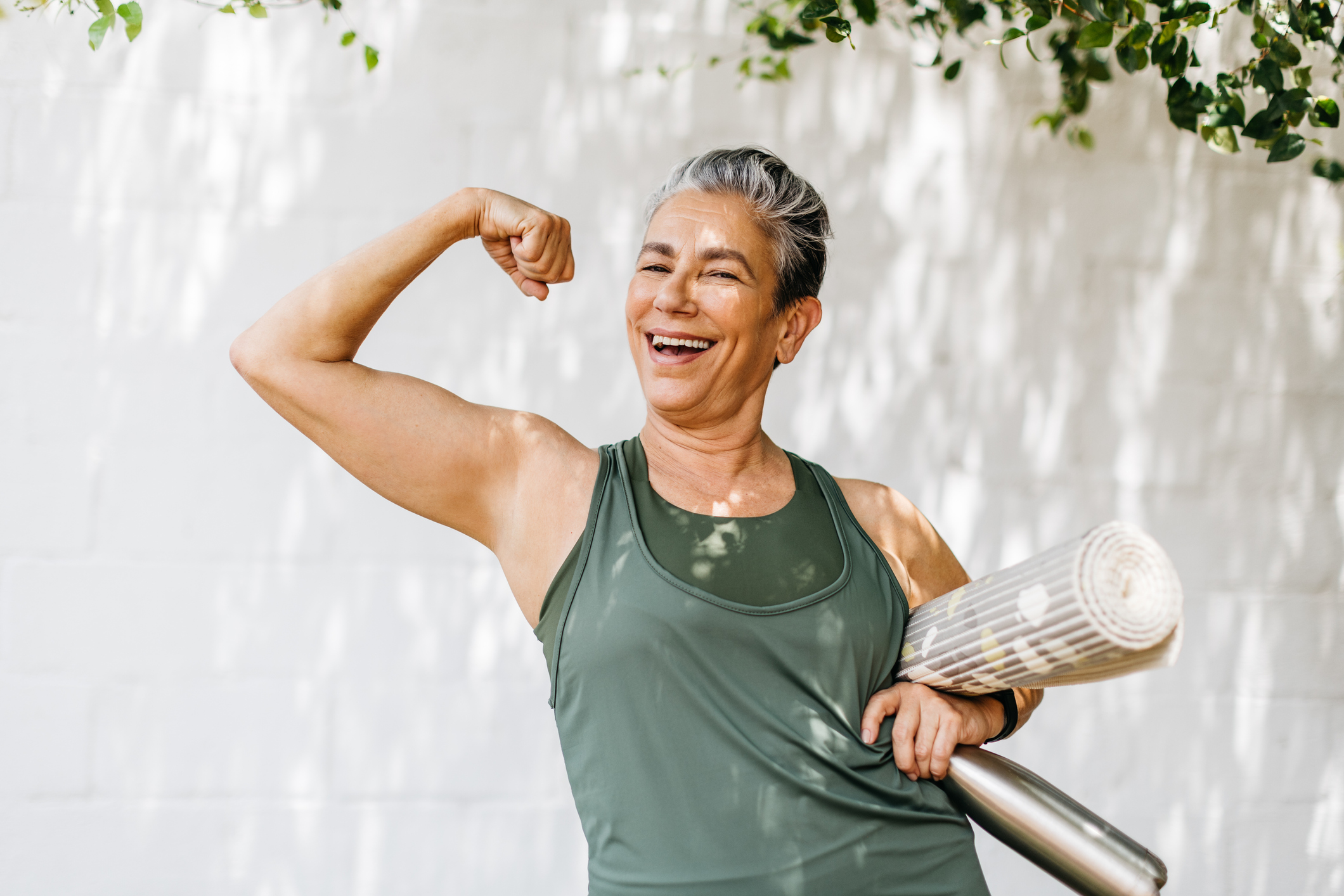 Photograph of a woman joyfully flexing her muscles, celebrating her achievement after weight loss. The image radiates positivity, strength, and self-confidence, emphasizing the empowering journey of personal transformation through fitness and healthy lifestyle choices.
